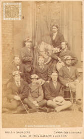 Un grupo de estudiantes junto a la bandera del Queen's College de Cambridge
