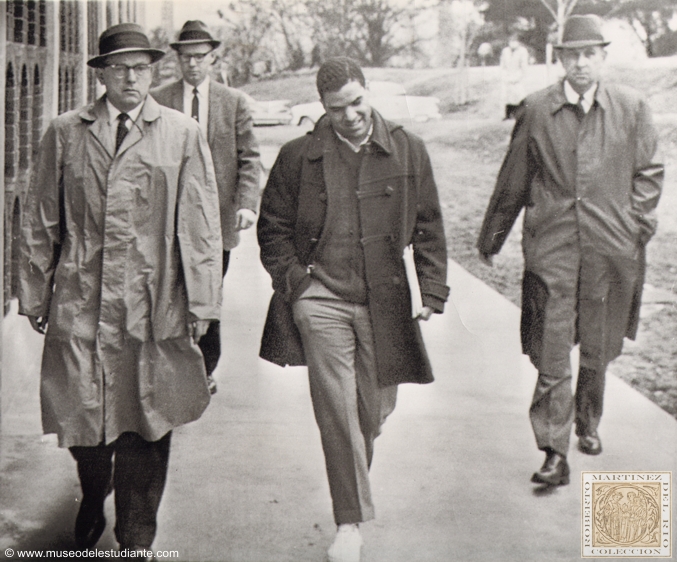 Negro resumes classes. Hamilton Holmes, a Negro student, is escorted to his first class by university officials at the University of Georgia in Athens today following a court order for readmission. Demonstrations forced his withdrawal last week